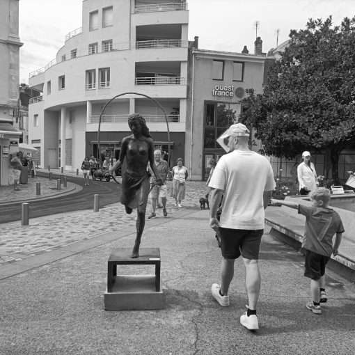 Un homme regarde une statue de femme aux seins nus.